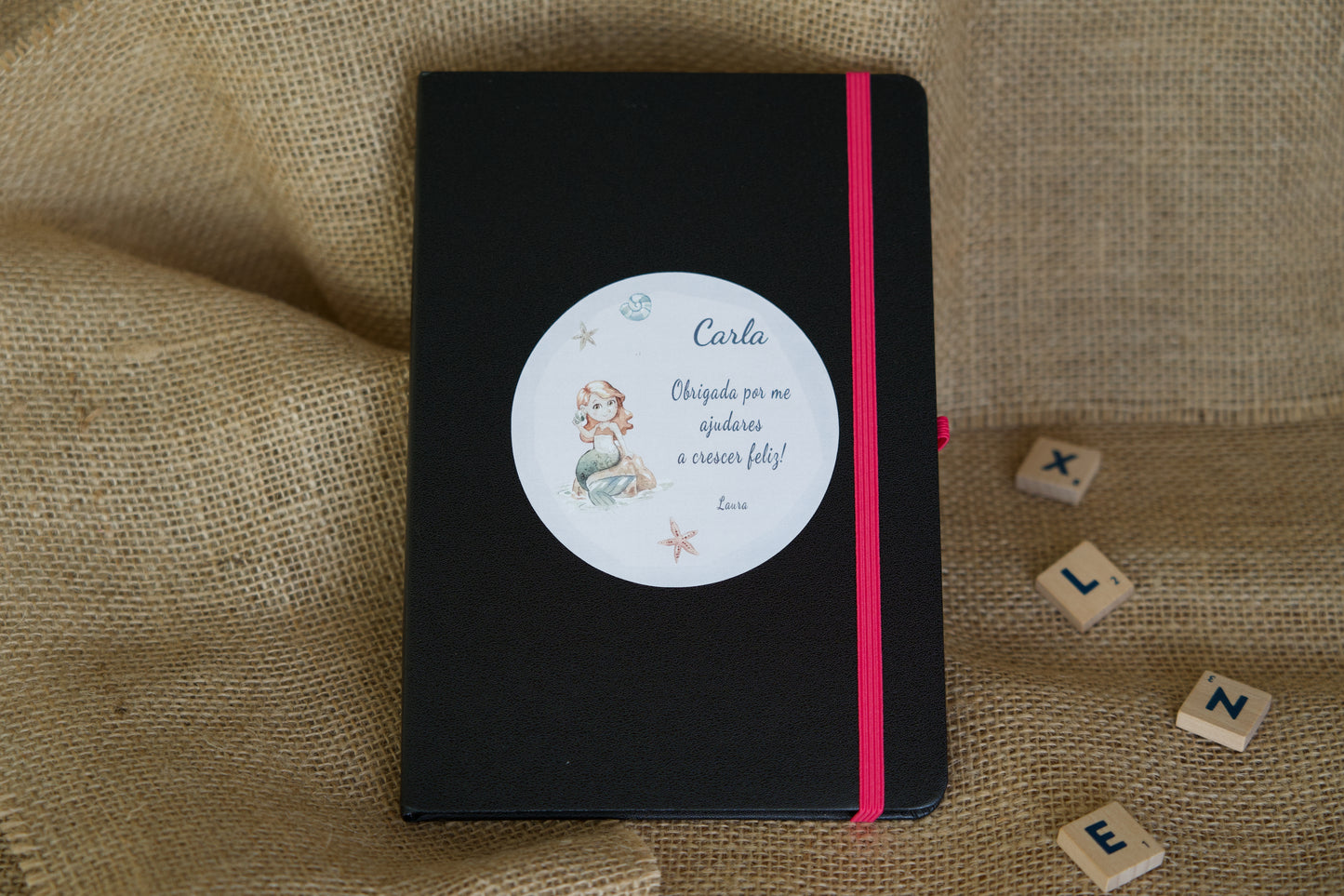 Detalhe do bloco de notas A5 personalizado para educadora — folhas lisas marfim, elástico e suporte para caneta