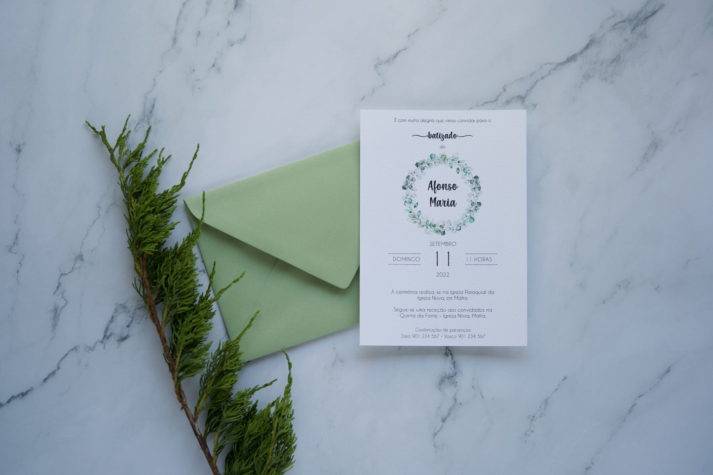 Convite de batizado verde e branco com design de folhagem botânica e envelope verde seco